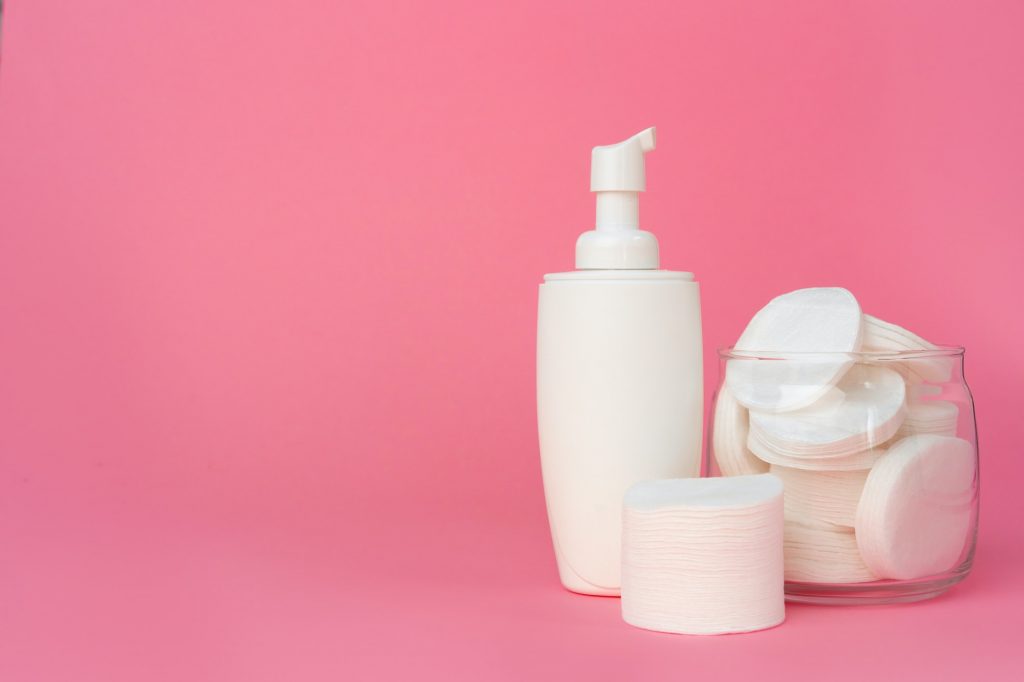 Stack of cotton discs and skicare cosmetic bottle